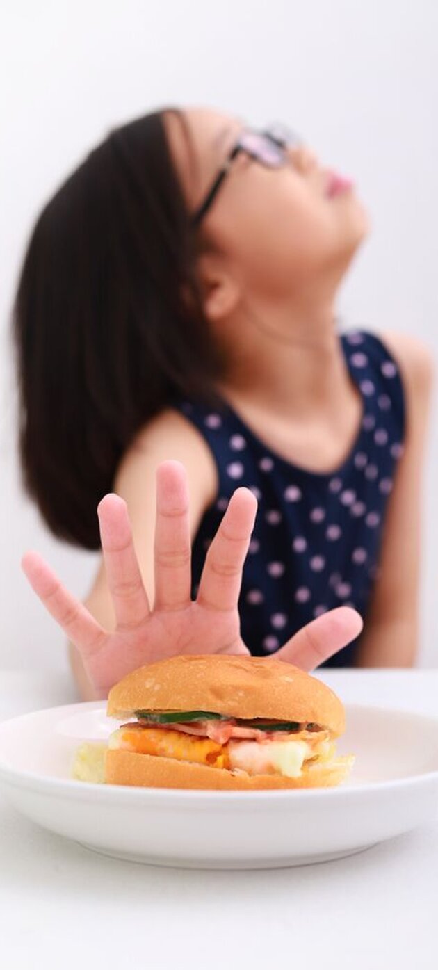 Asian little girl getting bored of food with appetite loss, no hungry habit, eating disorder.